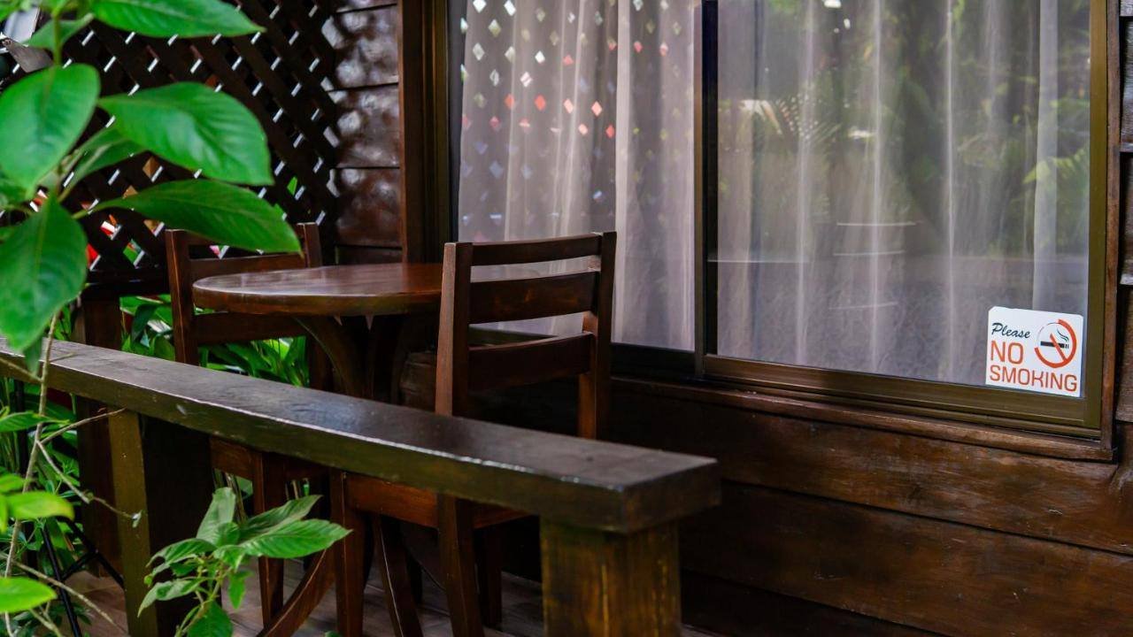 La Fortuna Waterfall Bungalows: small porch with a table and chairs among the plants